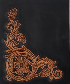 an intricately carved piece of wood on a black surface with brown trimmings