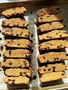 several slices of chocolate chip cookie dough on a baking sheet, ready to go into the oven