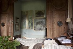 an old bedroom with wood paneling and paintings on the wall