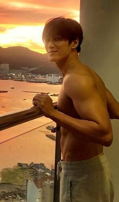 a shirtless young man standing on top of a balcony