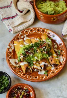 some tacos and guacamole are sitting on the table