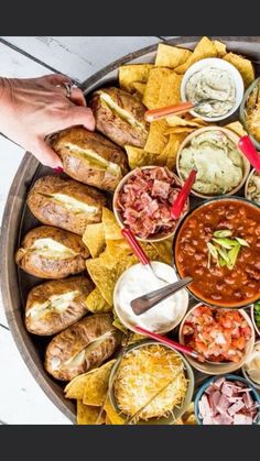 a platter filled with lots of different types of food and dipping sauces on it