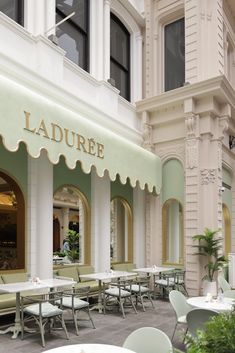 tables and chairs in front of a building with an awning over the entrance to it