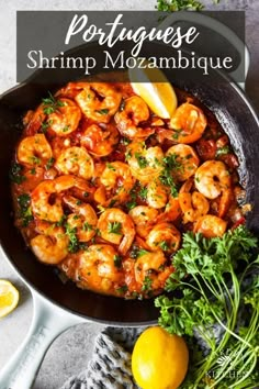 a skillet filled with shrimp and lemons on top of a table next to some parsley