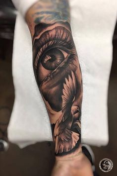 a man's arm with an eye tattoo on it