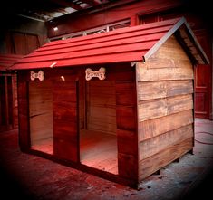 a dog house made out of wood with red roof and shingles on the sides