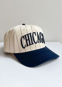 **Exclusive A&W Design**Our iconic Chicago Puff Cap with an old school sporty twist. This exclusive embroidered Chicago Puff Cap features an ivory and navy pinstriped base with a navy brim.Adjustable snapback enclosure.One size fits most. Navy Collegiate Baseball Cap With Curved Brim, Navy Baseball Cap With Logo Patch And Curved Bill, Collegiate Navy Adjustable Snapback Hat, Navy Vintage Cap Hat, Blue Collegiate Six-panel Baseball Cap, Baseball Cap, Old School, Chicago, Navy