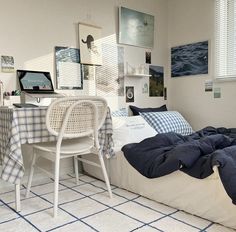 a bedroom with a bed, desk and computer on it's side in front of a window