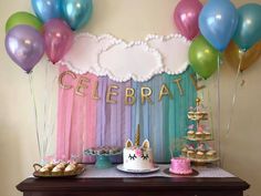 a table topped with lots of balloons and cake