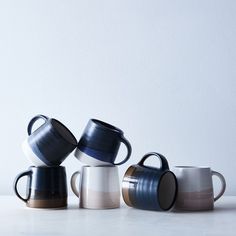 three coffee mugs sitting next to each other on a table