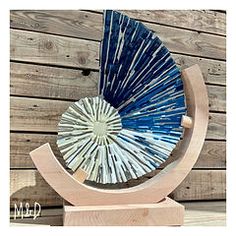 a blue and white fan sitting on top of a wooden stand