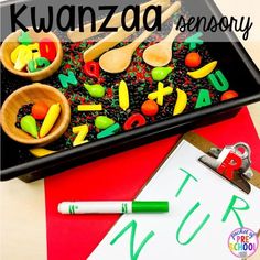 a black tray with letters and spoons on it next to a clipboard that says kwanzaa memory