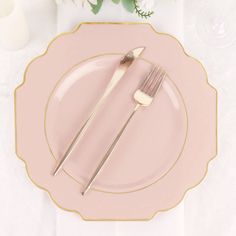 a pink plate topped with two forks and a knife next to a vase filled with flowers