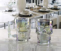 two glass cups sitting on top of a table