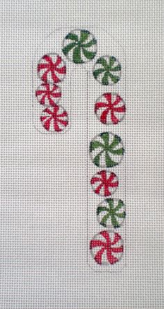 the letter p is decorated with red and green candy canes on white linen fabric