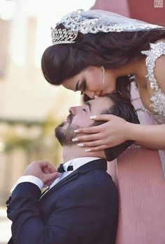 a bride and groom kissing on a bench