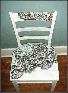 a white chair with flowers painted on it and the words pretty up an old chair spray paint through lace