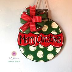 a christmas ornament hanging on the wall with a red bow and green polka dot design