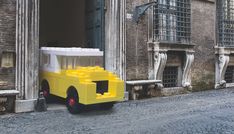 a yellow car is parked in front of an old building on a cobblestone street