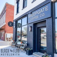 the outside of a coffee shop with tables and chairs