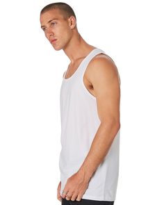 a man in white tank top standing with his hand on his hip and looking at the camera