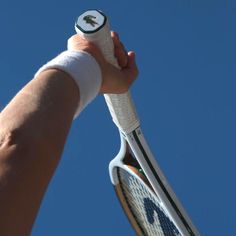 a hand holding a tennis racket in the air