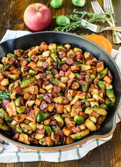 a skillet filled with brussel sprouts and apples