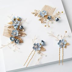 three hair combs with blue flowers and pearls on white paper next to each other