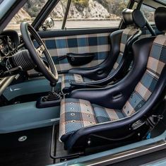 the interior of a car with blue and black plaid cloth on it's seats