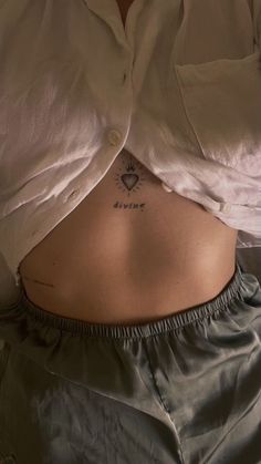 a woman's stomach with the word love tattooed on her lower back and side