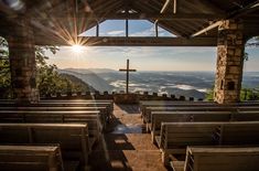 the sun shines brightly over an empty church with pews in front of it