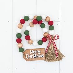 a christmas ornament with a tassel hanging from it's side on a white wall