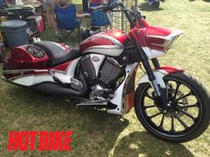 a red and white motorcycle parked in the grass