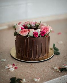 a chocolate cake with pink roses on top