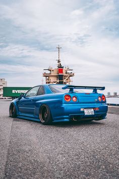 a blue car parked in front of a boat