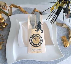 a white plate topped with a wooden clock on top of a table next to streamers