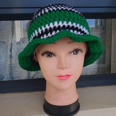 a mannequin's head wearing a green hat with black and white stripes