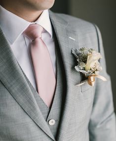 a man in a suit and tie with a boutonniere on his lapel