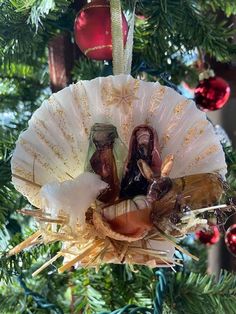 an ornament hanging from a christmas tree decorated with nativity figurines