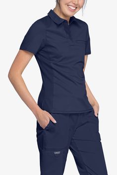 Trendy and flattering tucked in or untucked! The Cherokee Workwear Revolution Women s Snap Front Polo Scrub Top has design features for breathability and mobility. Each style from the Cherokee Workwear Revolution collection redefines the idea of a basic uniform with upgraded stretch comfort fabric and a modern classic fit. • Modern classic fit • Collared polo neck • 3 snaps inside hidden front placket • 1 left welt chest pocket • Short sleeve with mesh under sleeve panel • Front and back princes Deputy Clerk Shirts, Spa Front Desk Uniform, Us Navy Women Work, Cute Nursing Scrubs, Wonderwink Scrubs, Top Polo, Cute Scrubs, Scrubs Uniform, Scrub Jackets