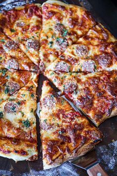 a pizza cut into eight slices on top of a wooden cutting board next to a knife