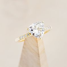 a yellow gold engagement ring with a single diamond on the top and side stones around the band