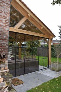 an enclosed patio with glass walls and wooden roof