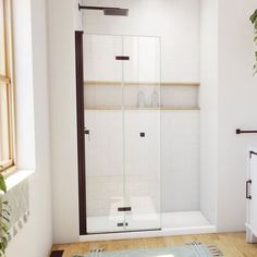 a bathroom with a glass shower door and wood flooring, along with a rug on the floor