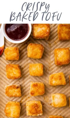 crispy baked tofu on a baking sheet with ketchup and dipping sauce