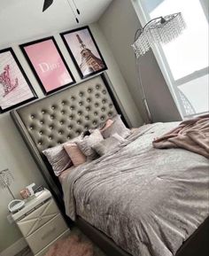 a bedroom with grey walls and pictures on the wall above the bed, along with pink rugs