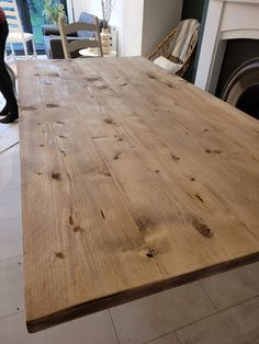 a large wooden table sitting in front of a fire place