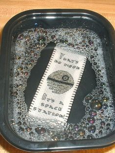 a plastic tray with some beads on it and a measuring tape in the middle that has been sequined