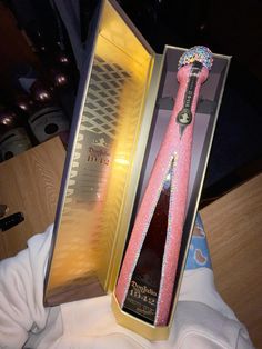 a bottle of booze in a box with a pink tie on it's head