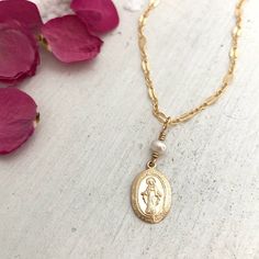 Our Miraculous Medal Dainty Necklace is a beautiful reminder of faith and the power of prayer. This beautiful necklace features a hand-wired accent stone of your choice on a delicately accented chain. Available in sterling silver or 14kt gold filled. Medal charm measures 9mm x 13mm. PLEASE STATE THE ACCENT STONE YOU WOULD LIKE IN MESSAGES UPON CHECKOUT. ACCENT STONES ARE PEARL AND PYRITE. BACK TO MY SHOP: https://www.etsy.com/shop/IsabelleGraceJewelry Spiritual Charms Necklace For Mother's Day, Spiritual Sterling Silver Necklace With Miraculous Medal, Spiritual Miraculous Medal Pendant Jewelry, Nickel Free Spiritual Necklaces, Spiritual Necklace With Miraculous Medal Gift, Spiritual Necklace For Mother's Day Blessing, Spiritual Miraculous Medal Oval Pendant Jewelry, Sterling Silver Miraculous Medal Jewelry, Dainty Necklace With Miraculous Medal